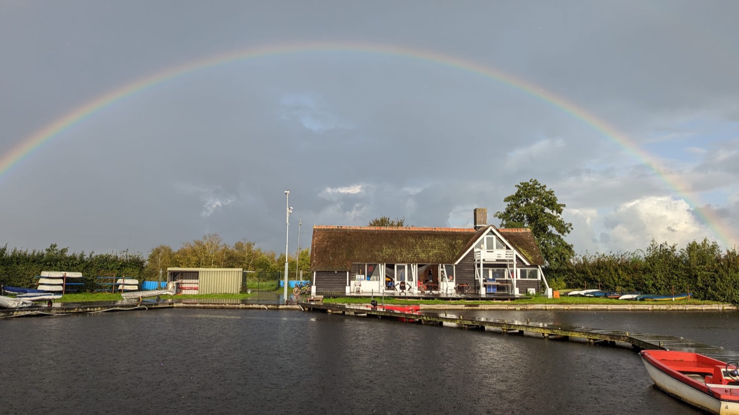 Regenboog boven het clubhuis aan het water